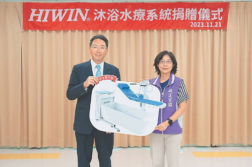 上銀科技董事長卓文恒（左）捐贈全套「電動沐浴水療系統」給敏道家園院長涂淑錦（右）。
